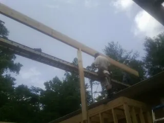 Carpenter setting a ridge beam over a new addition frame — Ice Dam Removal by Roofing Brothers in Freeport