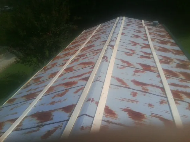Rusted metal roof panels with new wood purlins before replacement in Freeport