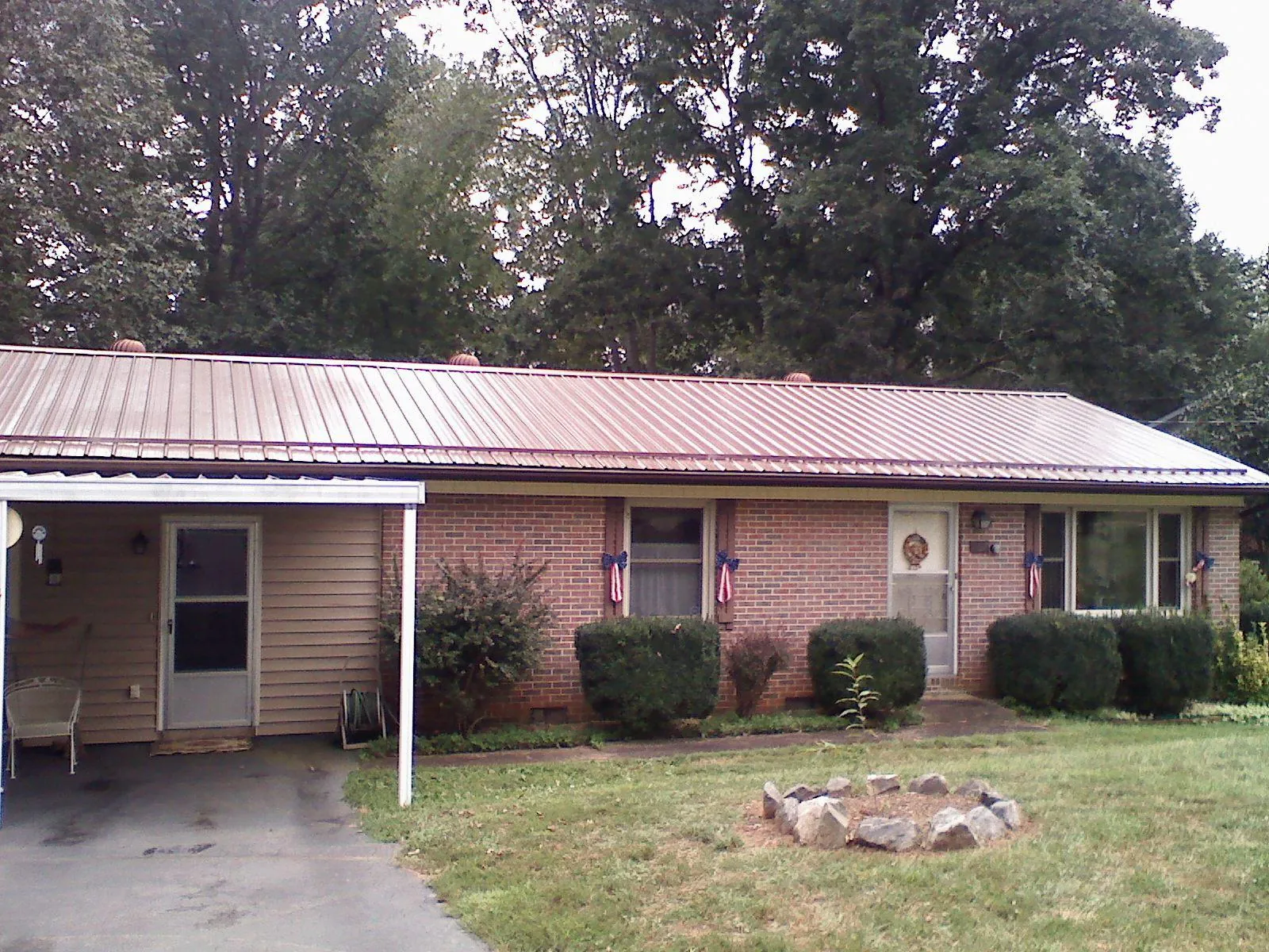 Bronze metal roof and carport on a brick ranch home — Roof Repair work by our crew in Freeport